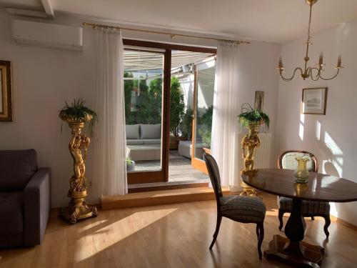 ein Wohnzimmer mit einem Tisch, Stühlen und einem Sofa in der Unterkunft Amadeus Apartment in Baden