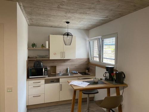 uma pequena cozinha com uma mesa e um micro-ondas em Pension Zur Alten Post em Untermeitingen