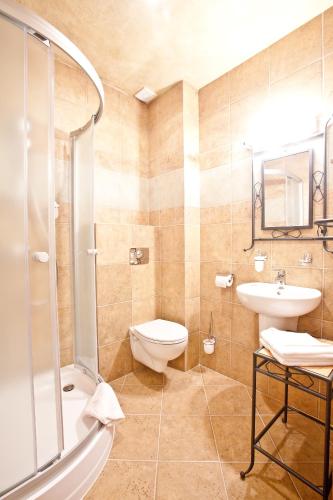 a bathroom with a toilet and a sink and a shower at Hotel Kotarz Spa&Wellness in Brenna