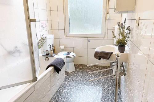 La salle de bains est pourvue de toilettes, d'un lavabo et d'une douche. dans l'établissement Apartments Bedburg-Hau, à Hau