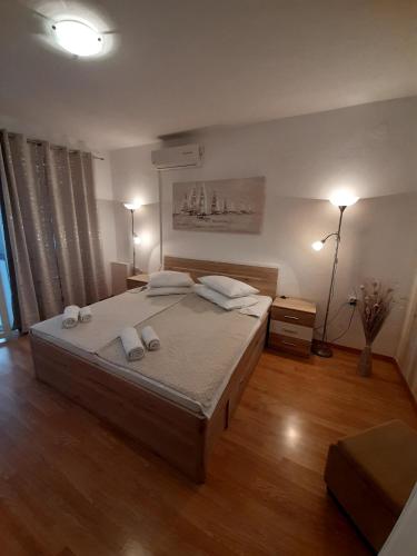 a bedroom with a large bed with two lamps on it at Apartments Adria in Jadrija
