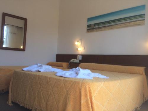 una habitación de hotel con dos camas con toallas en la Hostería Santa Bárbara de Villa Gesell