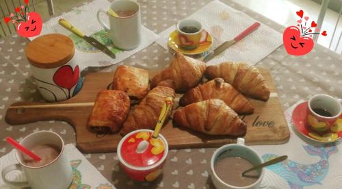 a table with a cutting board with croissants and cups of coffee at B&B Audafra in Crotone