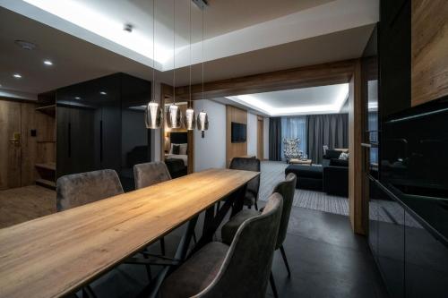 a dining room with a long wooden table and chairs at Hotel Meta Resort & Vine SPA in Szczyrk