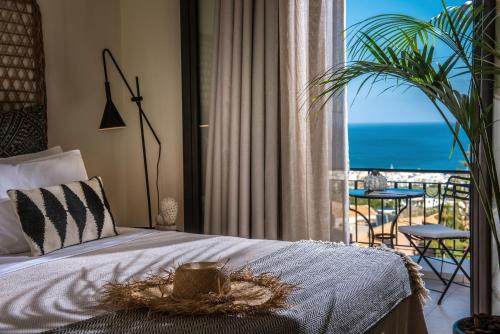 a bedroom with a bed with a view of the ocean at Creta Blue Boutique Hotel in Hersonissos