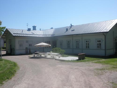 un edificio con una mesa de picnic y una sombrilla en Ulrikanhovi, en Lovisa