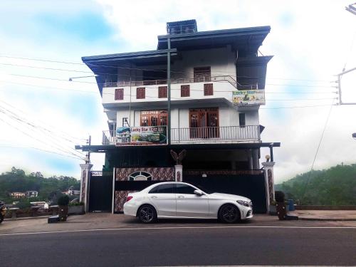 a white car parked in front of a building at Lucky Star View Inn in Bandarawela