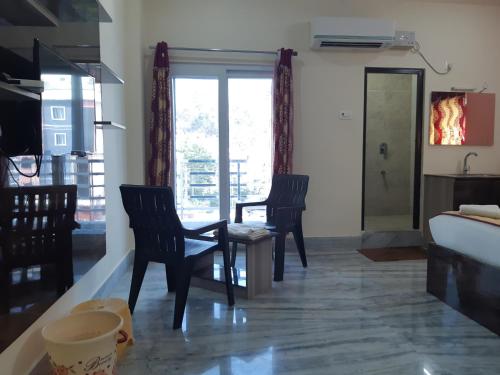 a living room with two chairs and a bed at Devansh Bhanu Residency DBR in Srikalahasti