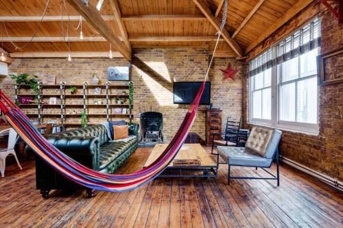 a hammock in a room with a couch and chairs at Penthouse Loft apartment with roof terrace Not for events or parties in London