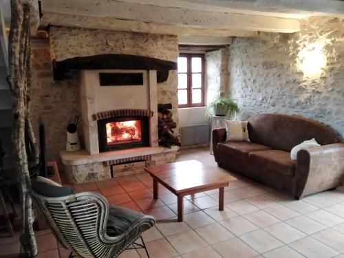 a living room with a couch and a fireplace at A deux pas de St Cirq Lapopie , Gite des Murets de l'isa in Esclauzels