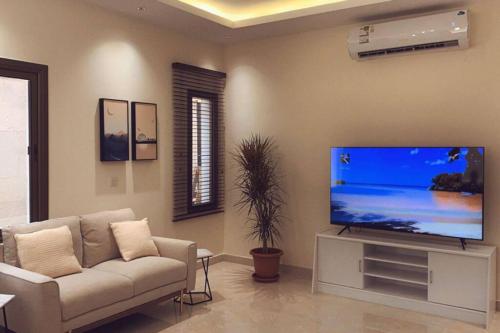 a living room with a couch and a flat screen tv at Luxury fully furnished villa ڤيلا مؤثثة in AlUla