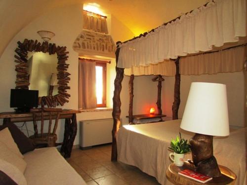 CrispianoにあるMasseria Quis Ut Deusのベッドルーム(天蓋付きベッド1台、ソファ付)