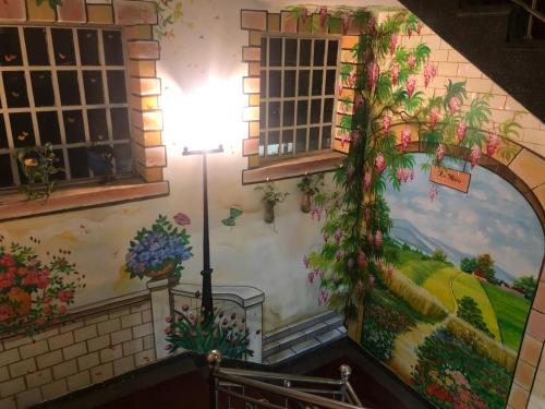 a mural on the wall of a building with flowers at Hotel An Nhien in Buon Ma Thuot