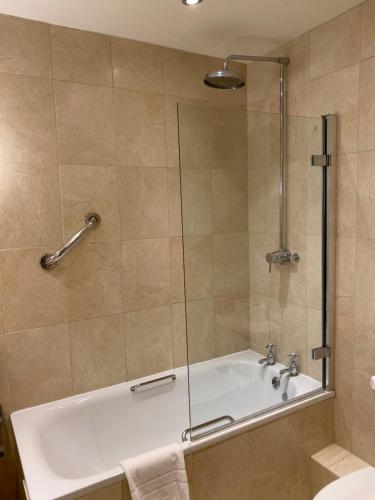 a bathroom with a bath tub with a shower at The Elizabeth House Hotel in Southampton
