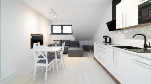 a kitchen and living room with a table and chairs at Triventi Mountain Residence, Sun & Snow in Karpacz