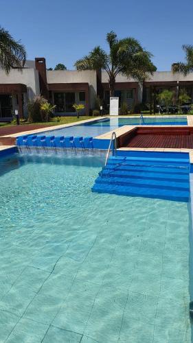 a swimming pool with blue chairs in the water at Amanzi Termal Rental in Concordia