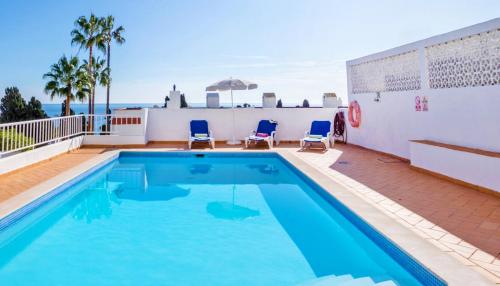 Una piscina con sillas y el océano al fondo. en Villa Turtle Beach by Algarve Vacation, en Albufeira