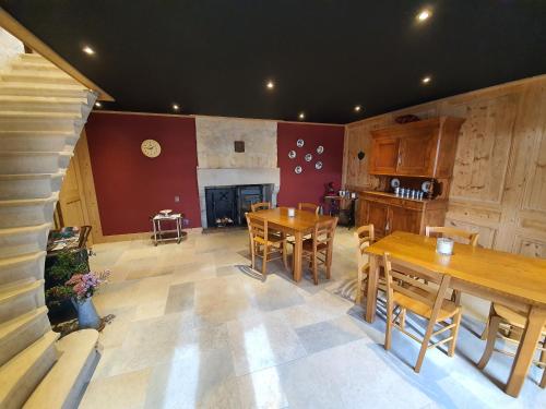 Habitación grande con mesas de madera y chimenea. en Chambres d'hôtes La Carrée, en Les Fins