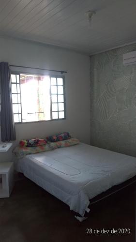 a bedroom with a large bed with a window at Villa Flor e Cor in Cavalcante