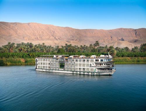 un gran barco en el agua con montañas en el fondo en Sonesta St George Nile Cruise - Aswan to Luxor 3 Nights from Friday to Monday en Asuán