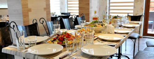 un tavolo con piatti e ciotole di cibo sopra di Хотел Дива a Blagoevgrad