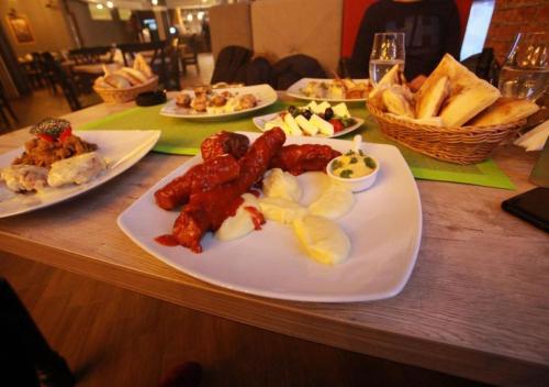 a table with plates of food on a table at Apartman D&V Milmari Resort S10 in Kopaonik