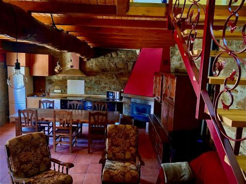 eine Küche und ein Esszimmer mit einem Tisch und Stühlen in der Unterkunft La casa de la valla azul (San Miguel de Langre) 