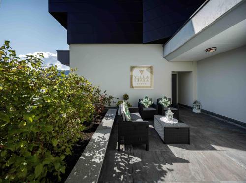 a patio with couches and plants on a building at Villa Ysara, Pool Villa with lake Lucerne View in Lucerne