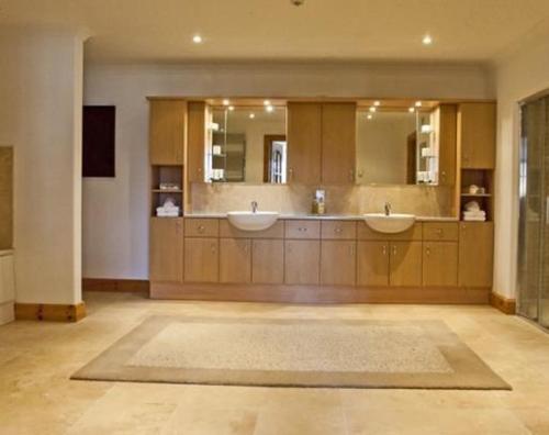 a large bathroom with two sinks and two mirrors at Sutherlands Guest House in Kingussie