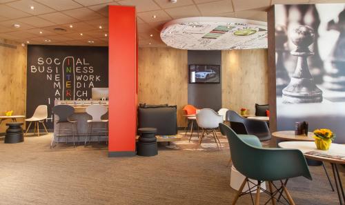a restaurant with chairs and tables and a chalkboard at ibis Poitiers Centre in Poitiers