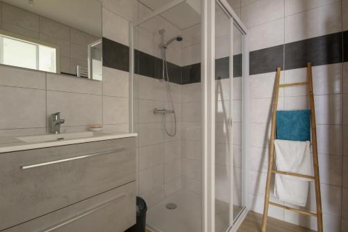 La salle de bains est pourvue d'une douche et d'un lavabo. dans l'établissement La Cabine du Moussaillon, à Saint-Gilles-Croix-de-Vie
