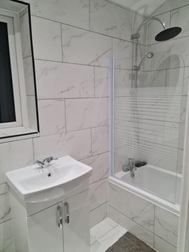 a white bathroom with a sink and a shower at Berrygate in Ipswich