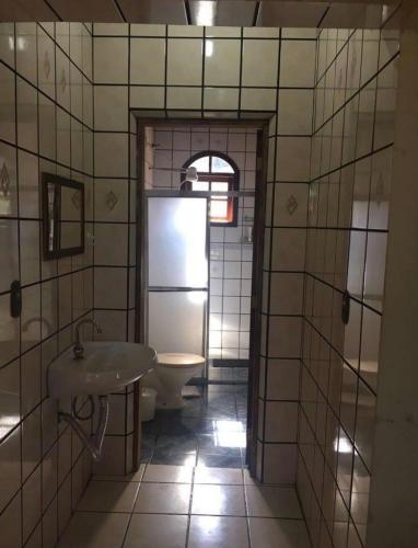 a bathroom with a sink and a refrigerator at Chácara das Violetas in Atibaia