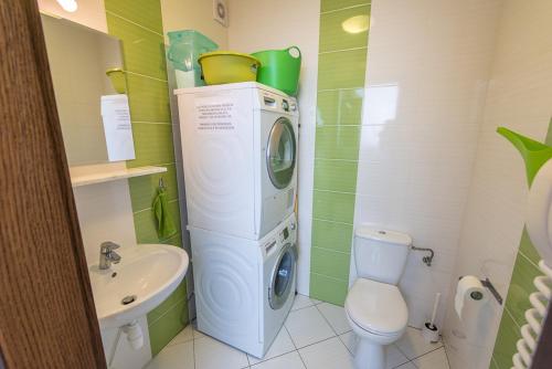 a washer and dryer in a bathroom with a toilet at Willa Północna in Karwia