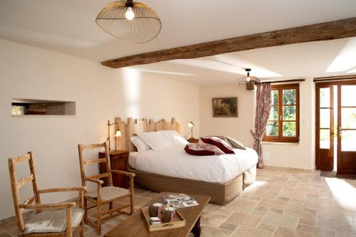 1 dormitorio con 1 cama, mesa y sillas en L'Hote Antique - MAISON D'HOTE- 4 Suites avec cuisine en Pichanges