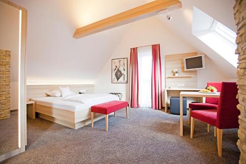 ein Schlafzimmer mit einem Bett und zwei roten Stühlen in der Unterkunft Hotel Krone OHG in Gerlingen