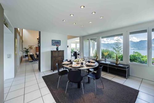 a dining room with a table and chairs in a house at Villa Ysara, Pool Villa with lake Lucerne View in Lucerne