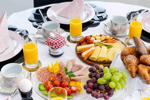 a table with plates of food and glasses of orange juice at Villa Ysara, Pool Villa with lake Lucerne View in Lucerne