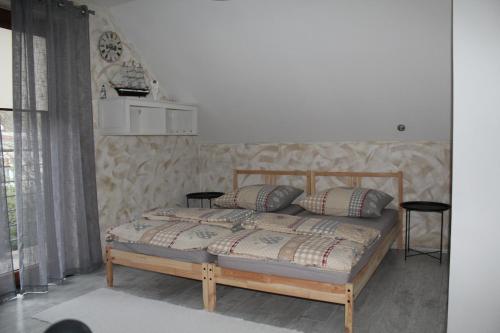 ein Schlafzimmer mit einem Holzbett mit zwei Kissen in der Unterkunft BERNAT apartman in Vrútky