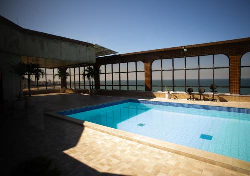 una piscina con vista sull'oceano di Suite Praia da Costa Confort a Vila Velha