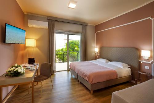una camera d'albergo con letto, scrivania e finestra di Mercury Rooms a Cagliari