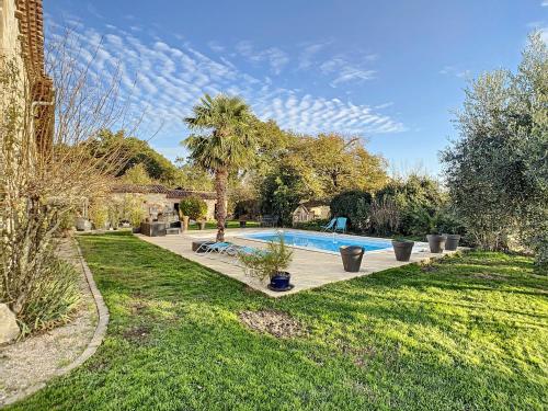 une piscine dans une cour avec un palmier dans l'établissement GITES STE CATHERINE, à Teyssode