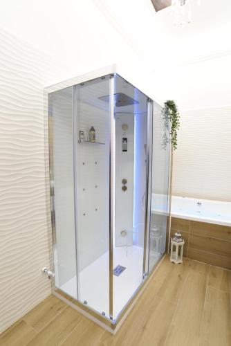 a glass shower in a room with a tub at Vittorio Veneto Private SPA in Sulmona