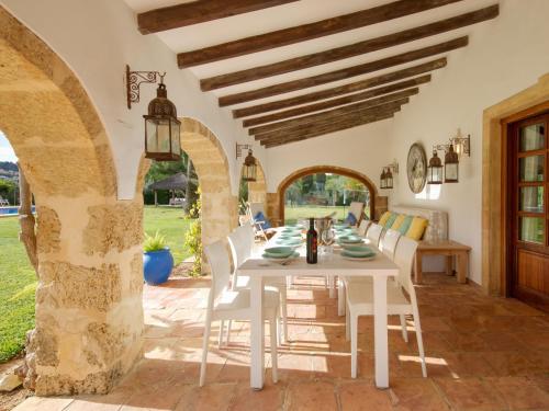 a dining room with a white table and chairs at Holiday Home El Torrero by Interhome in Benitachell