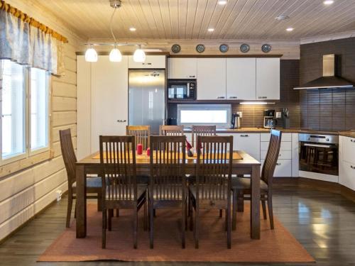 uma cozinha e sala de jantar com uma mesa de madeira e cadeiras em Holiday Home Villa sofia by Interhome em Vuokatti