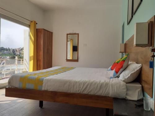 a bedroom with a large bed and a balcony at EDEN Paradisee in Ooty