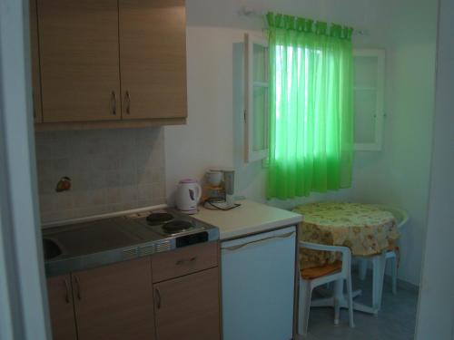 a kitchen with a green curtain and a table at Villa Vasiliki in Vitalades