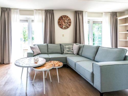 sala de estar con sofá azul y mesa en Holiday Home Citta Romana-1 by Interhome en Hellevoetsluis