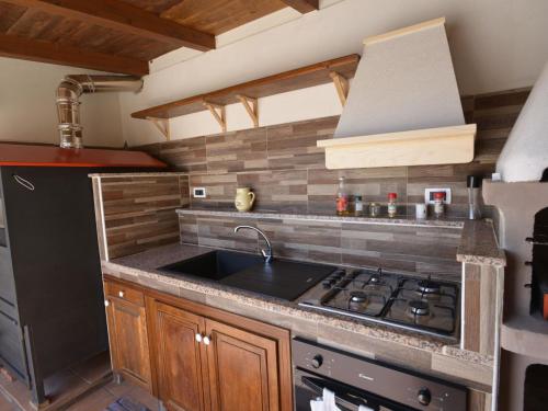a kitchen with a sink and a stove top oven at Villa Eureka by Interhome in Solarino