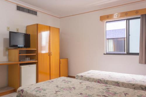 um quarto de hotel com duas camas e uma televisão em OYO Real Palace Hotel, Teresina em Teresina